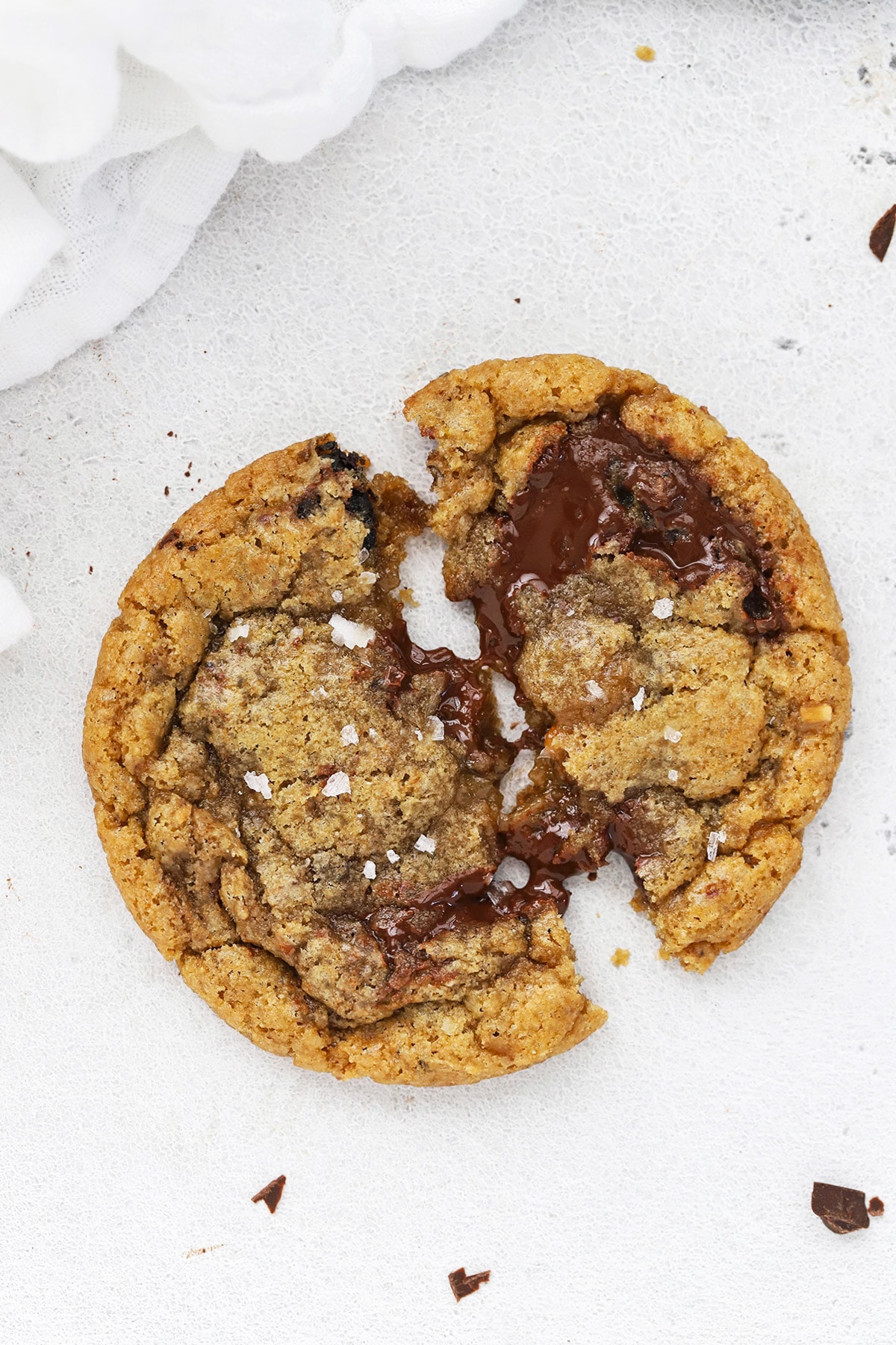 Overhead image of a gooey gluten-free brown butter toffee chocolate chip cookie being pulled apart