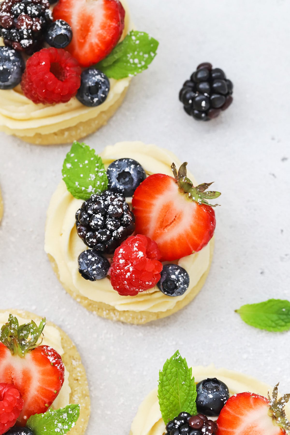 Front view of gluten-free fruit pizza cookies topped with berries and powdered sugar