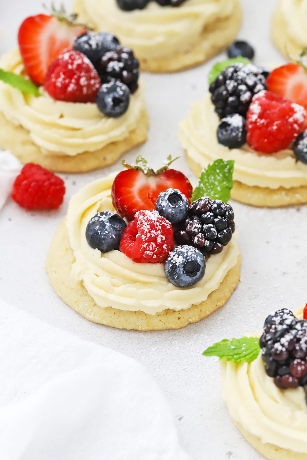 Front view of gluten-free fruit pizza cookies topped with berries and powdered sugar