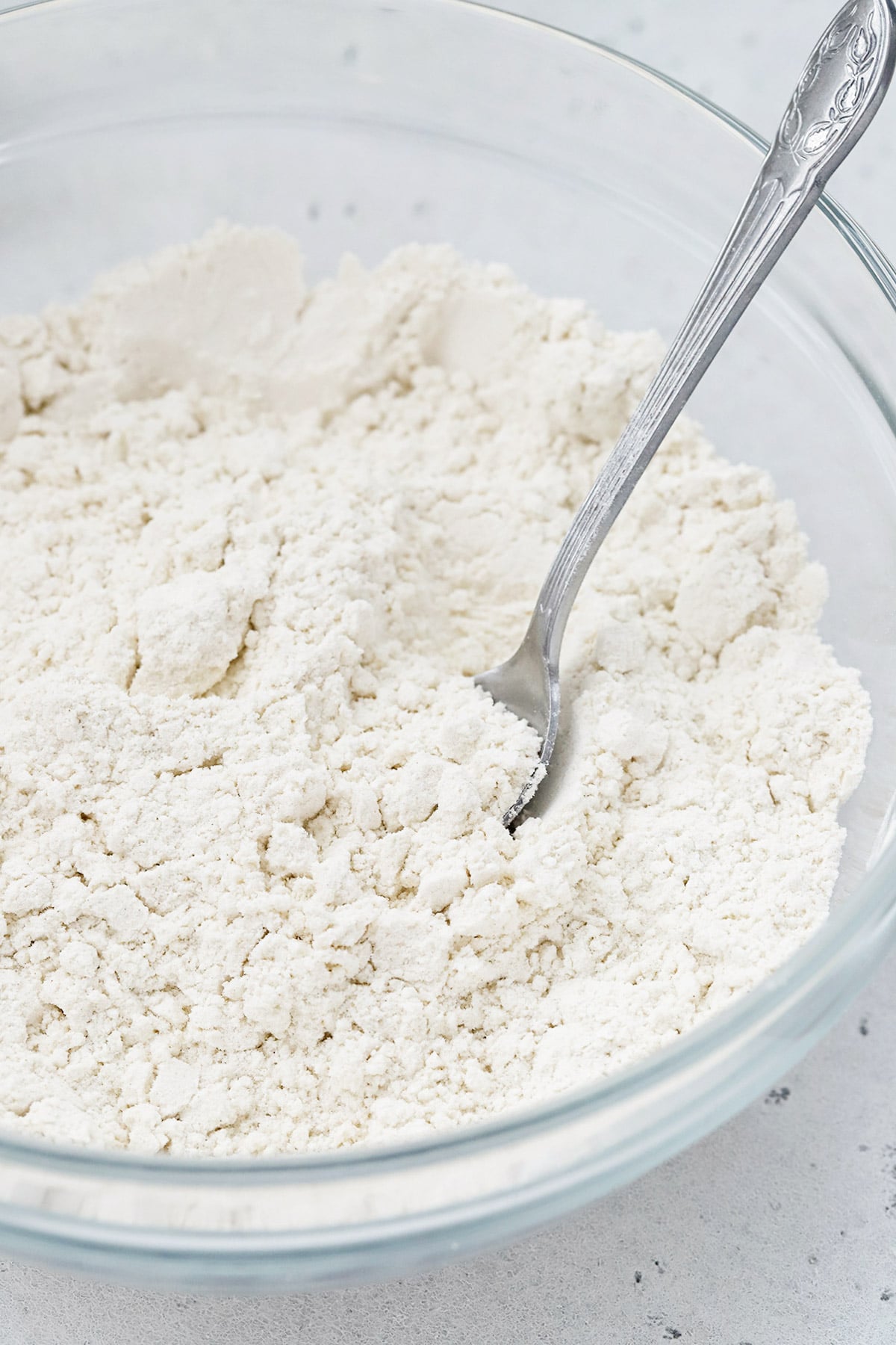 Front view of a spoon in a bowl of flour