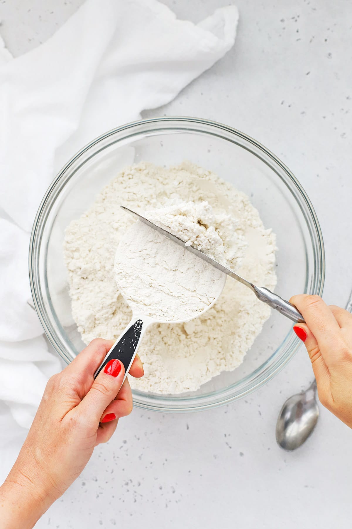 Overhead view of someone using the scoop and level method to measure flour correctly