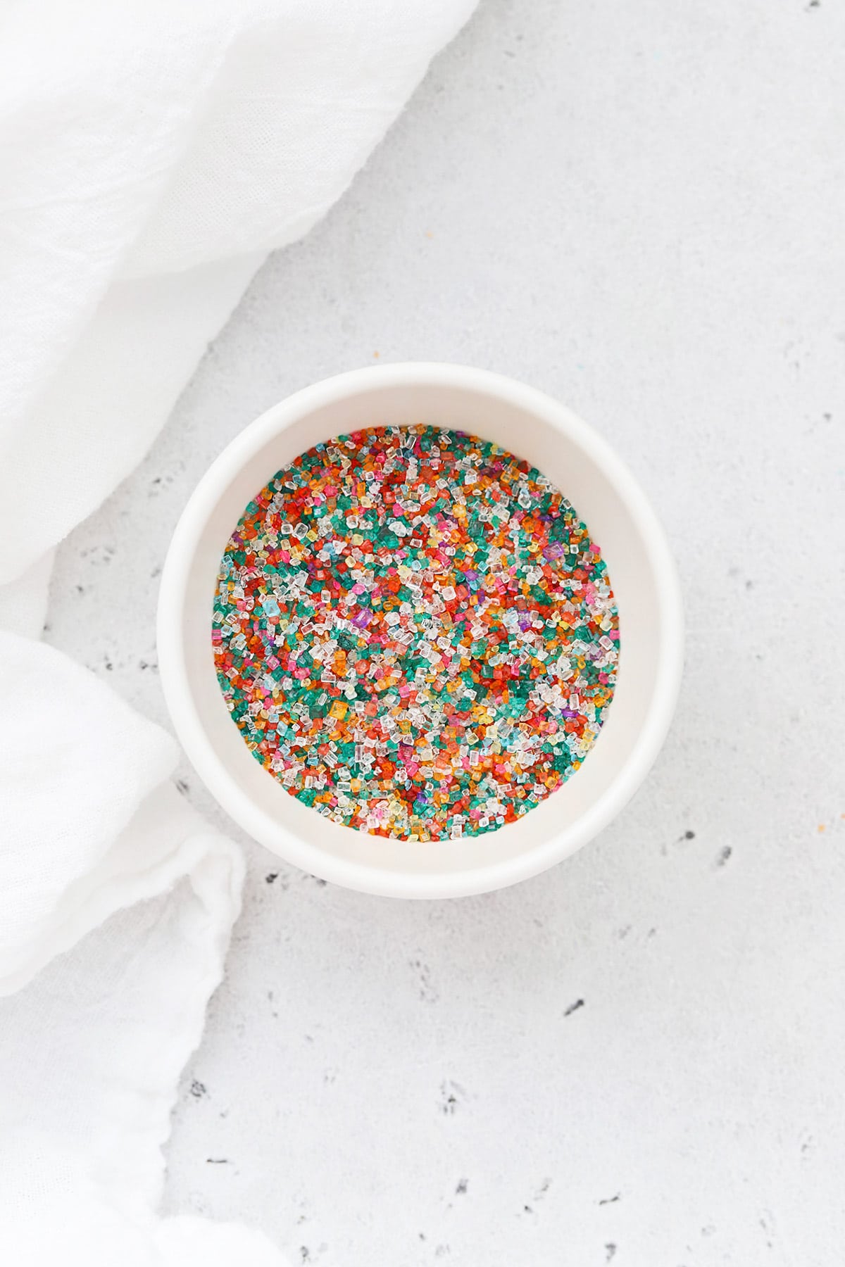 Colorful sparkling sugar sprinkles in a white bowl
