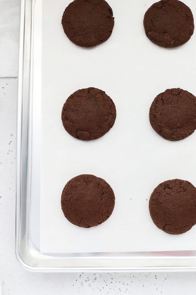 Overhead view of freshly baked gluten-free Crumbl chocolate cake cookies on a baking sheet