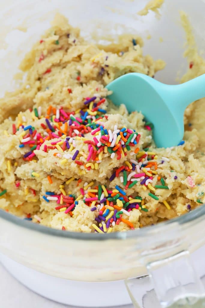 Front view into a mixer with gluten-free funfetti sprinkle sugar cookie dough