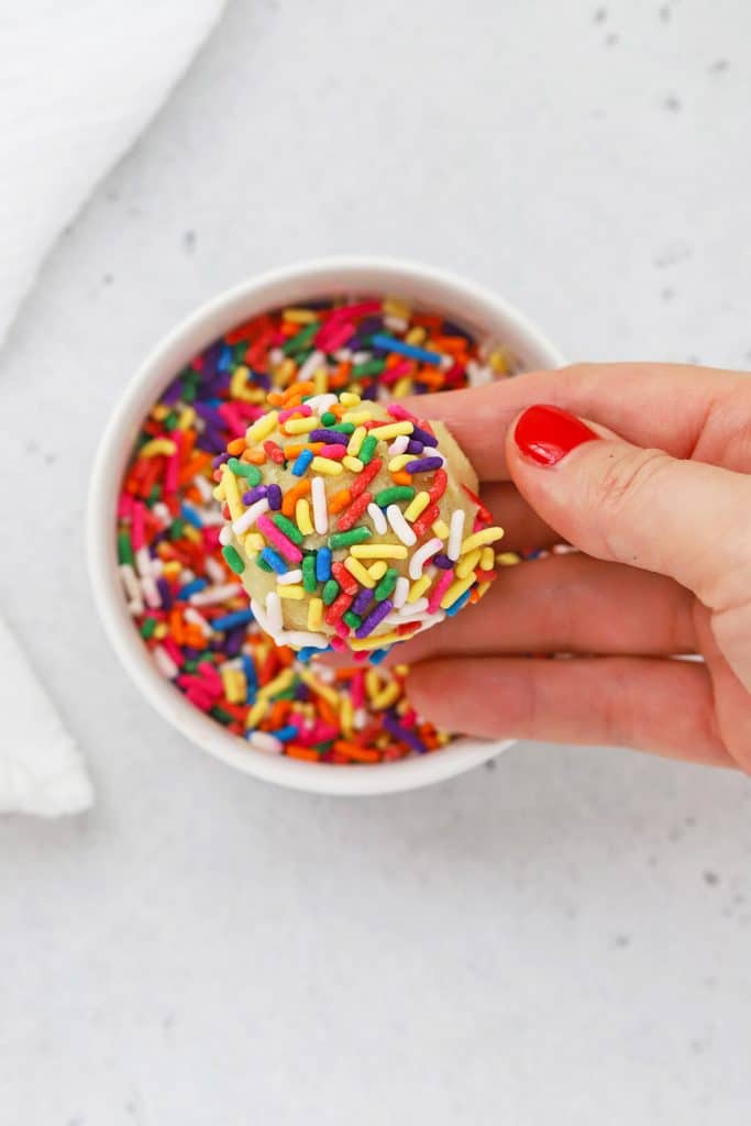 a gluten-free sugar cookie dough ball dipped colorful jimmies sprinkles