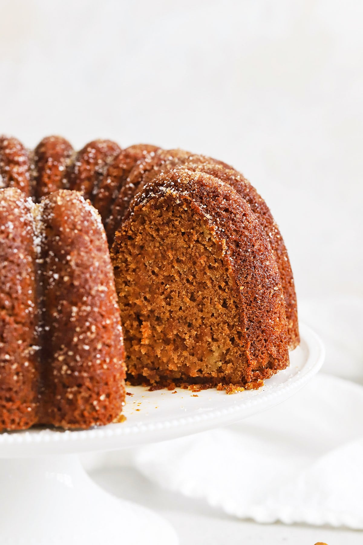 Gluten Free Apple Spice Bundt Cake with a slice cut out, revealing a gorgeous tender center