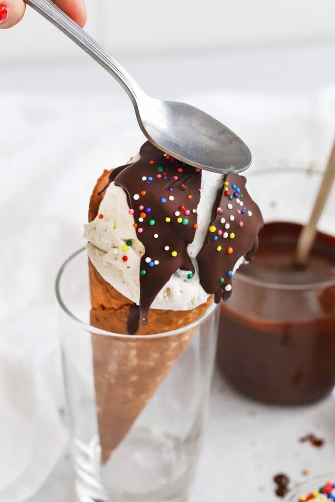 Cracking the magic chocolate shell on a vanilla ice cream cone with a spoon