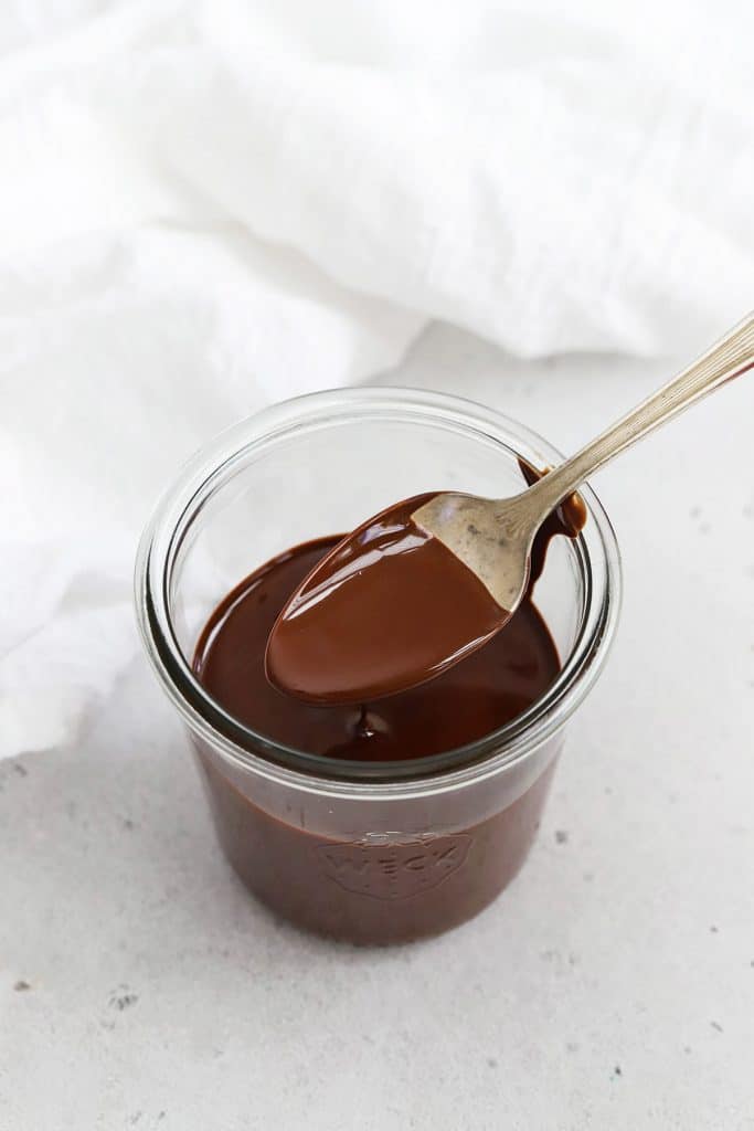 Spooning melted magic chocolate shell out of the jar to drizzle on ice cream