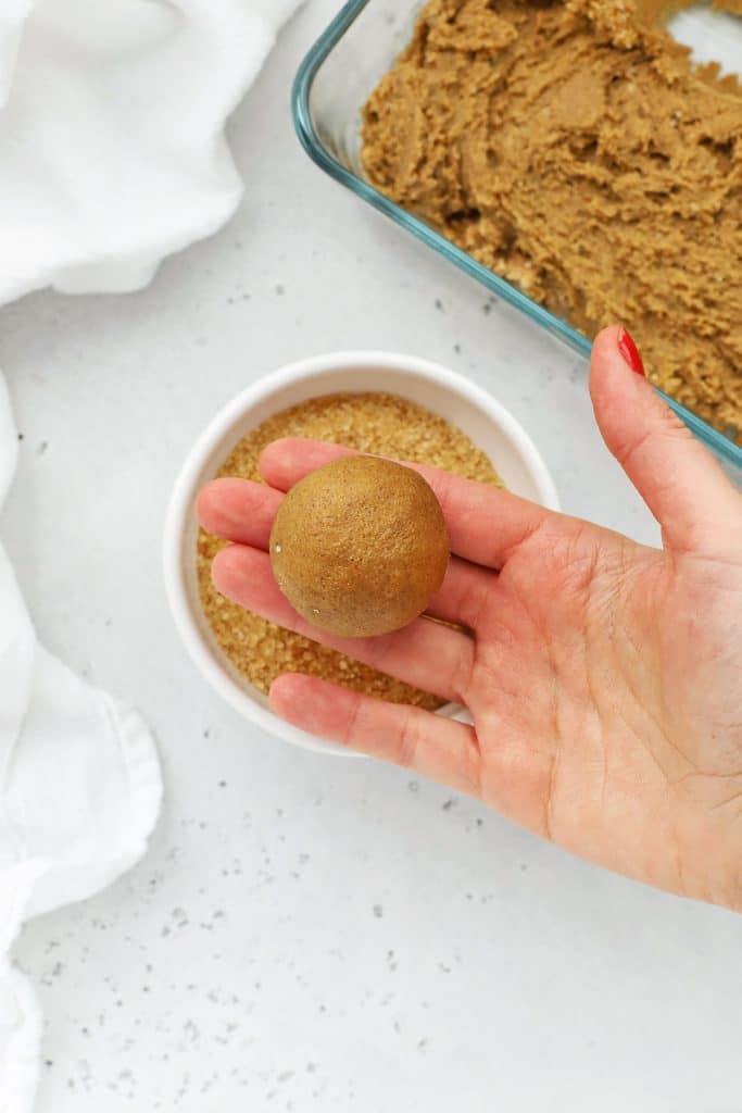 Rolling gluten-free ginger cookie dough into balls for baking