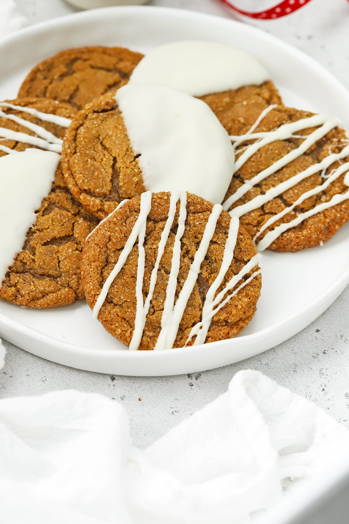 Front view of soft, chewy gluten-free ginger cookies drizzled and dipped in white chocolate