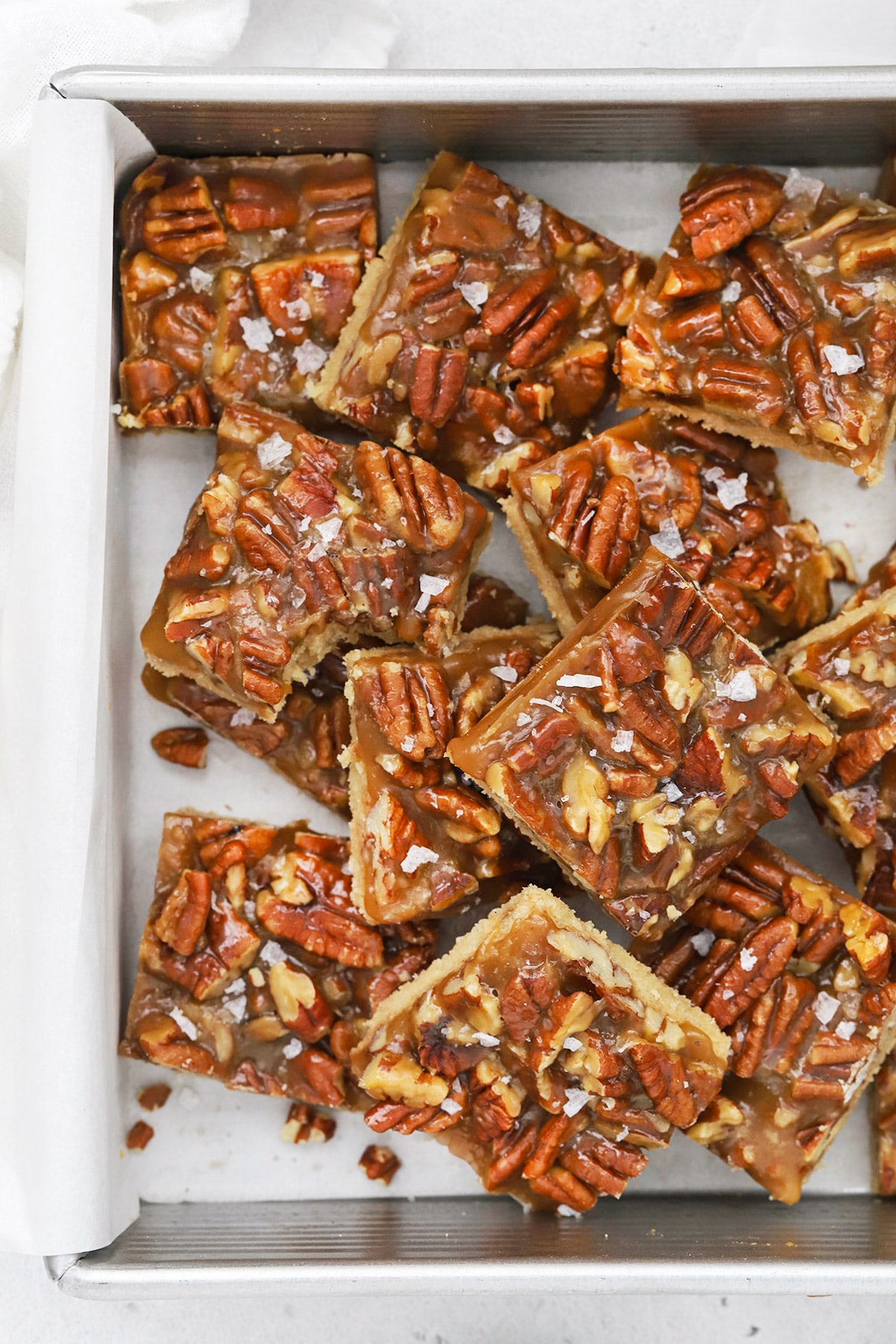 Overhead view of sliced gluten-free salted caramel pecan bars in a baking dish