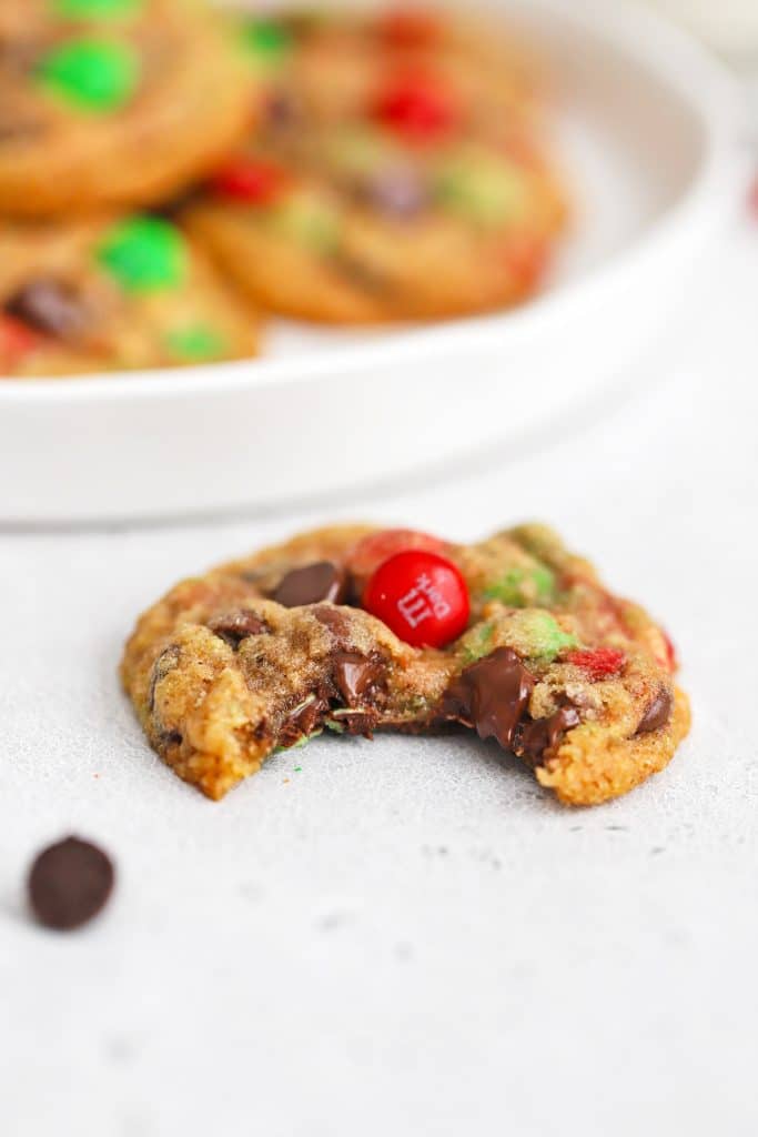 Front view of gluten-free m&m cookies with a bite taken out of it