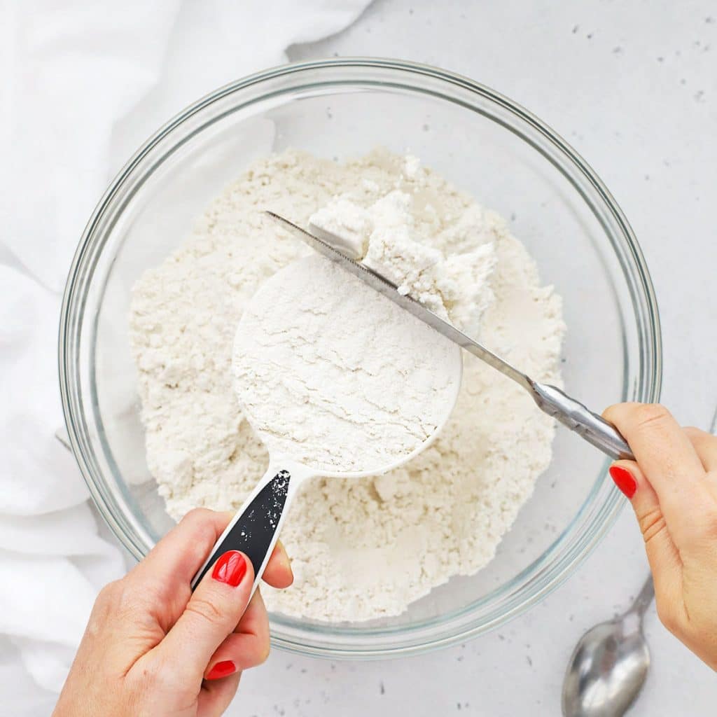 Overhead view of someone using the scoop and level method to measure flour correctly