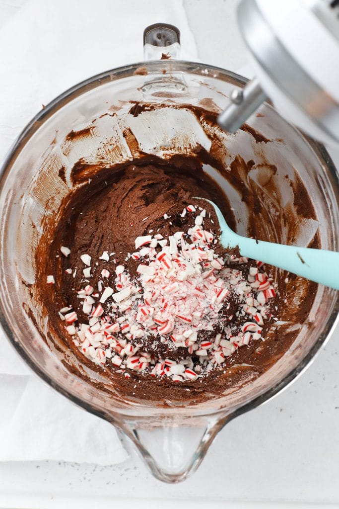 Overhead view of adding crushed candy cane in peppermint chocolate crinkle batter