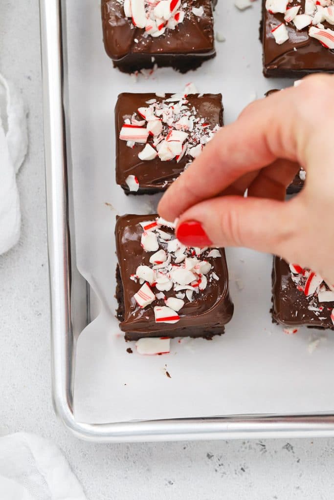 Sprinkling crushed candy cane on gluten-free peppermint brownie bites