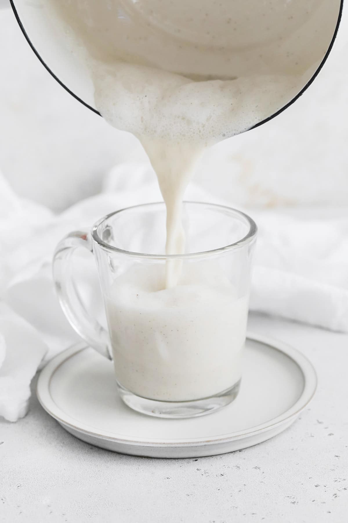 Pouring a vanilla steamer into a glass mug