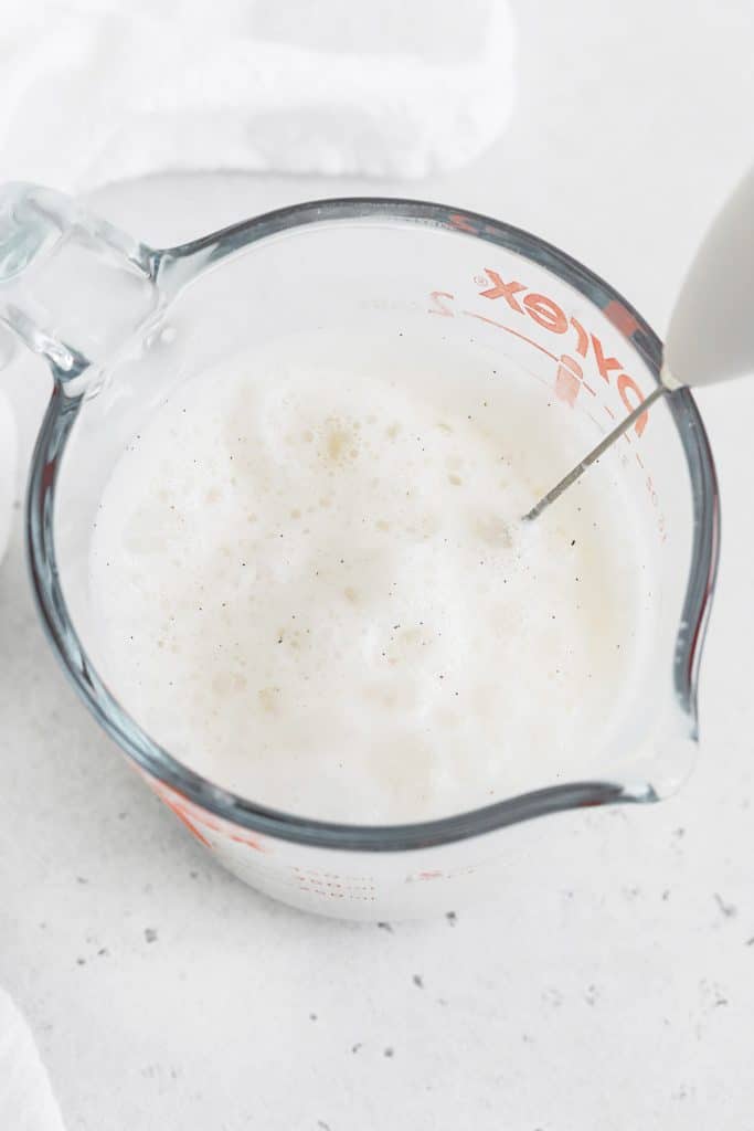 Using a frother to add foam to a vanilla steamer