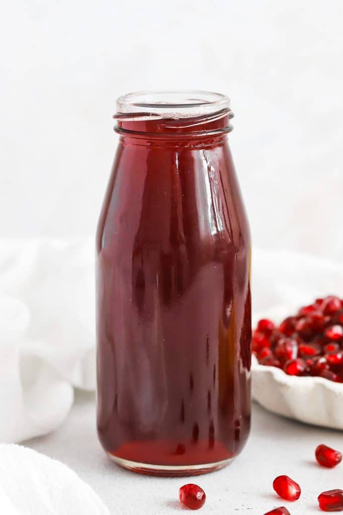 Front view of homemade grenadine syrup in a jar.