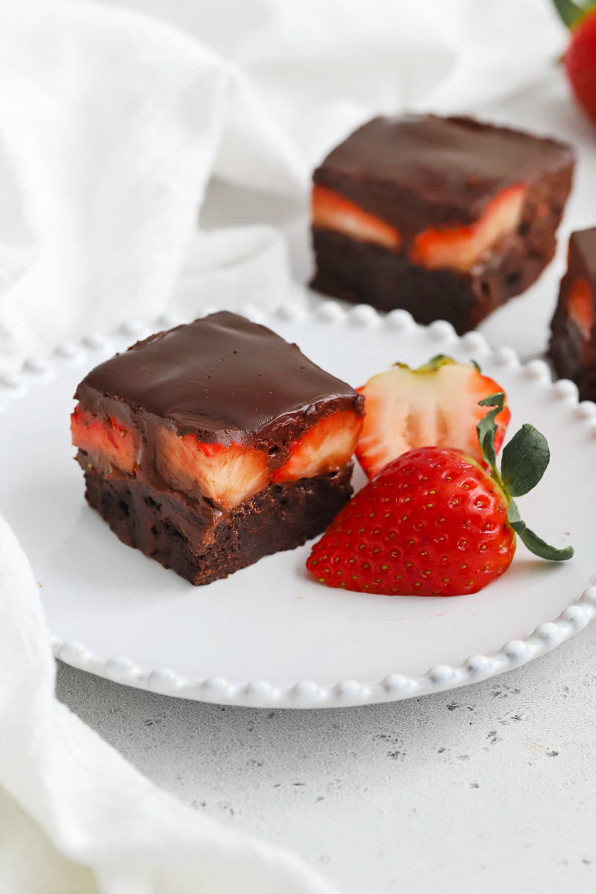 Front view of gluten-free chocolate covered strawberry brownies on a plate