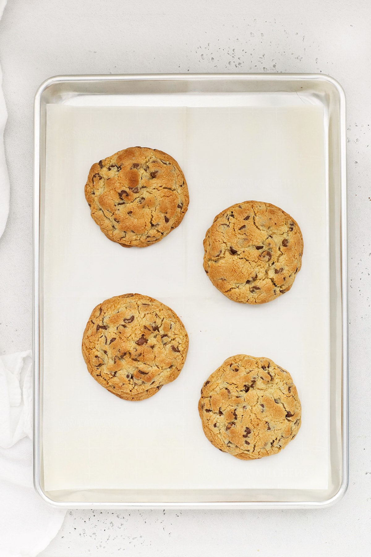 Four thick gluten-free chocolate chip cookies hot from the oven