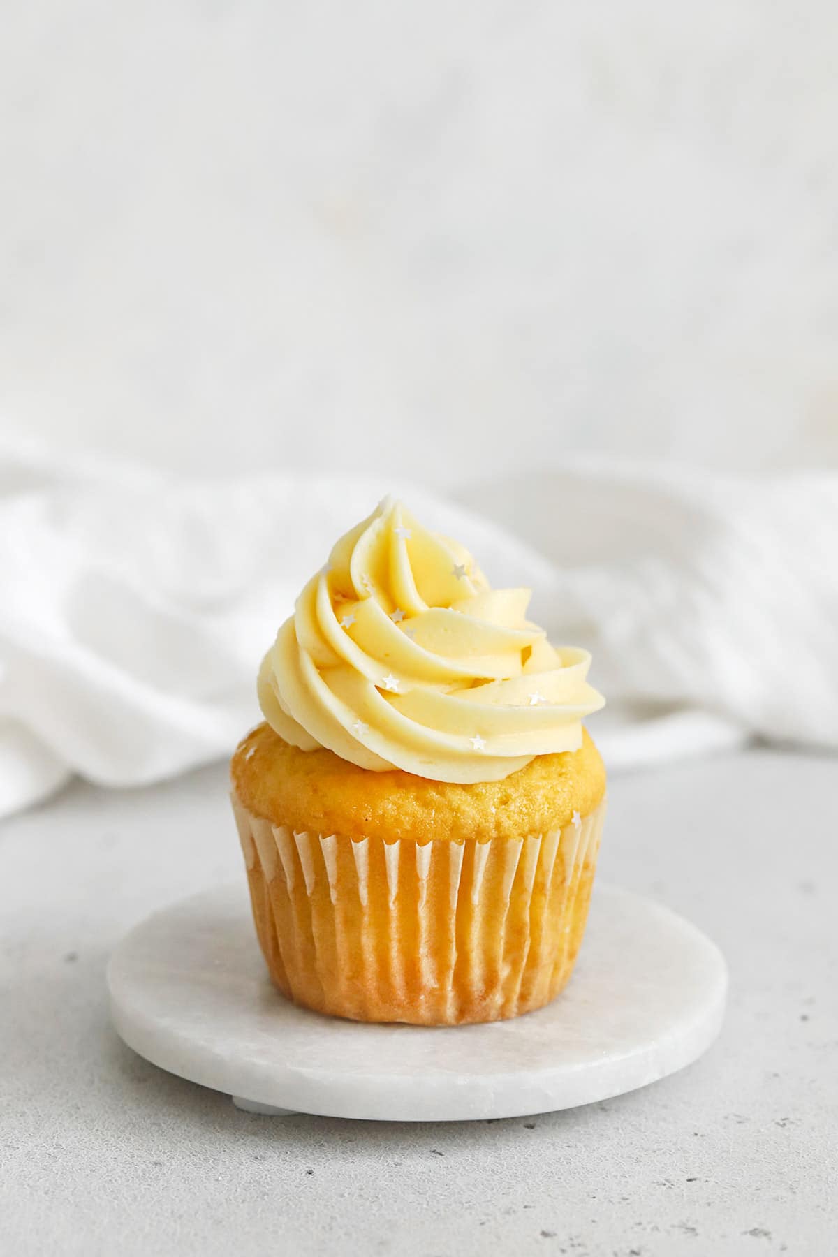 gluten-free vanilla cupcake topped with vanilla buttercream and edible silver star glitter