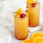 Front view of Sweets & Thank You Sweet Sunrise Mocktail garnished with orange and maraschino cherry