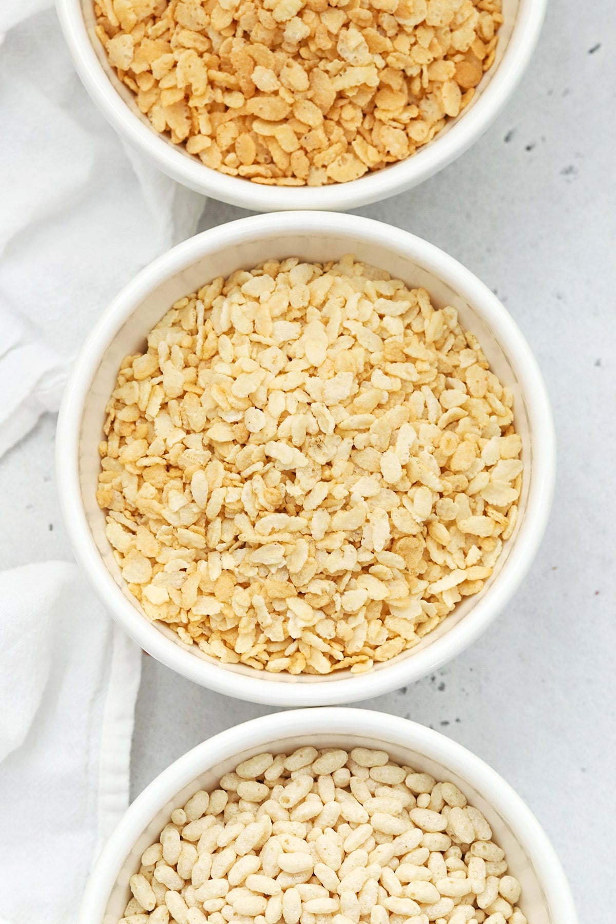 Overhead view of three bowls of gluten-free rice krispies cereals