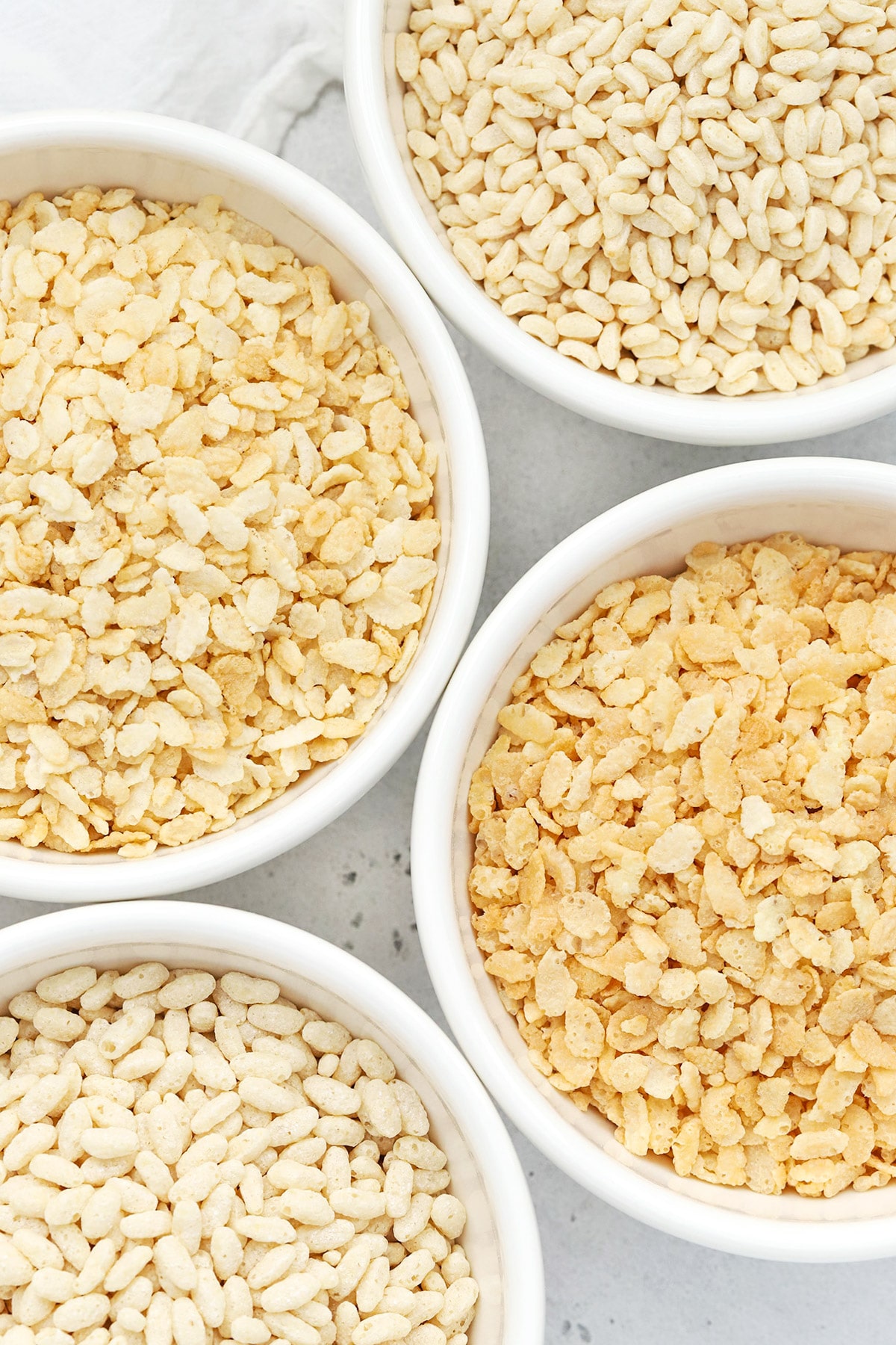Overhead view of four bowls of gluten-free crisp rice cereals