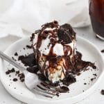 Front view of a slice of gluten-free grasshopper pie topped with whipped cream and chocolate sauce