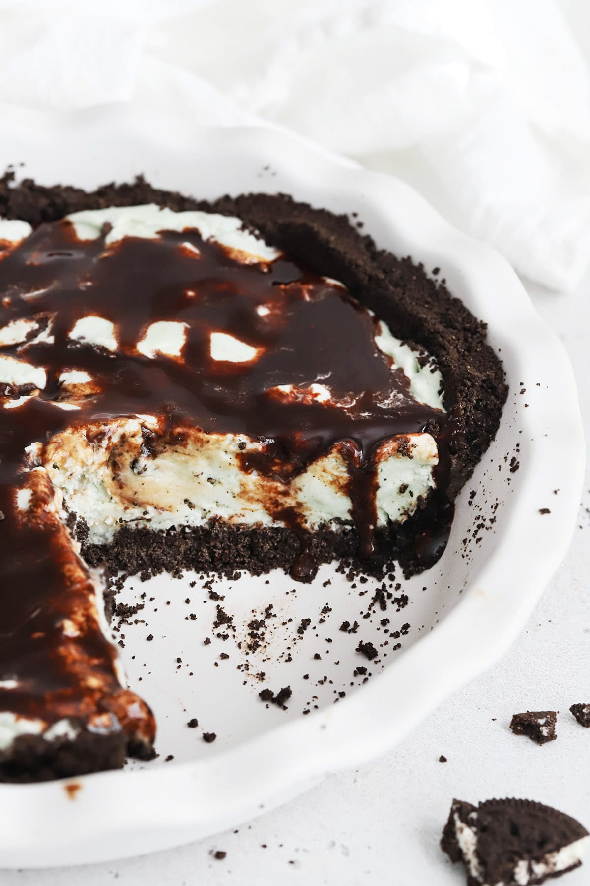 Front view of a gluten-free grasshopper pie covered with chocolate sauce