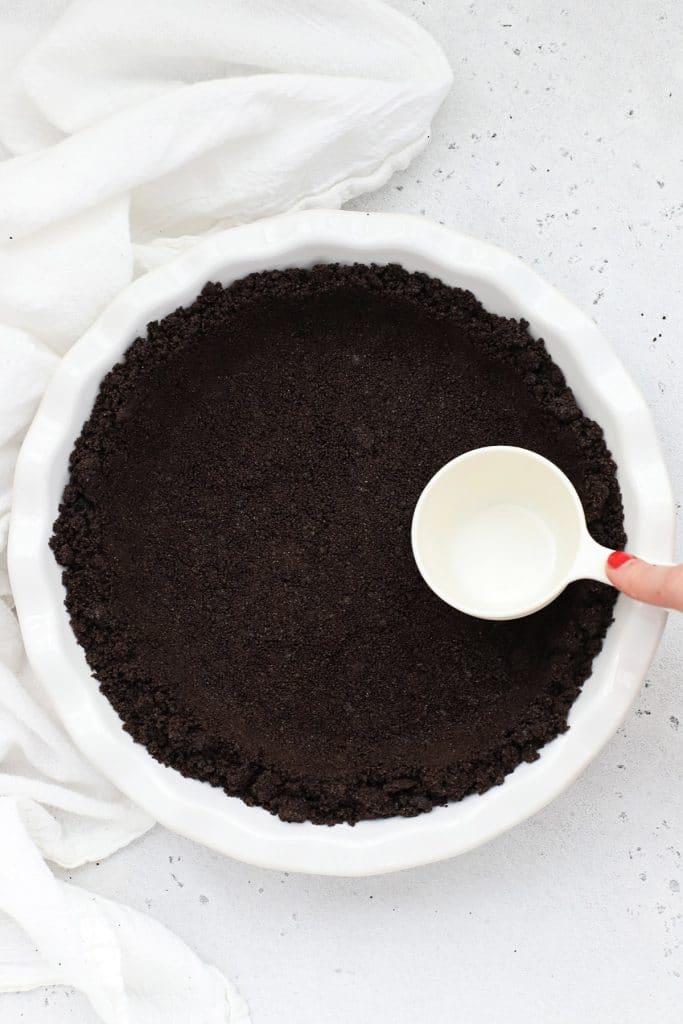 Patting down oreo crumbs for a gluten-free oreo crust