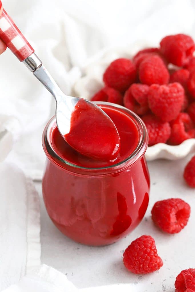 Front view of fresh raspberry coulis in a jar