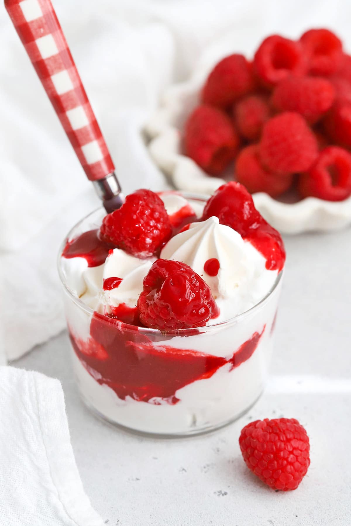 Front view of raspberry Eton mess made with mini meringues, raspberry sauce, fresh raspberries, and whipped cream