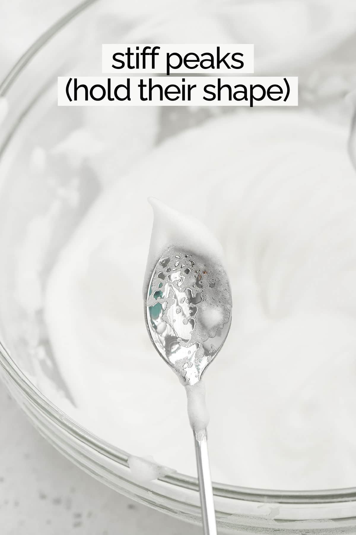 Egg whites whipped to stiff peaks on the end of a spoon