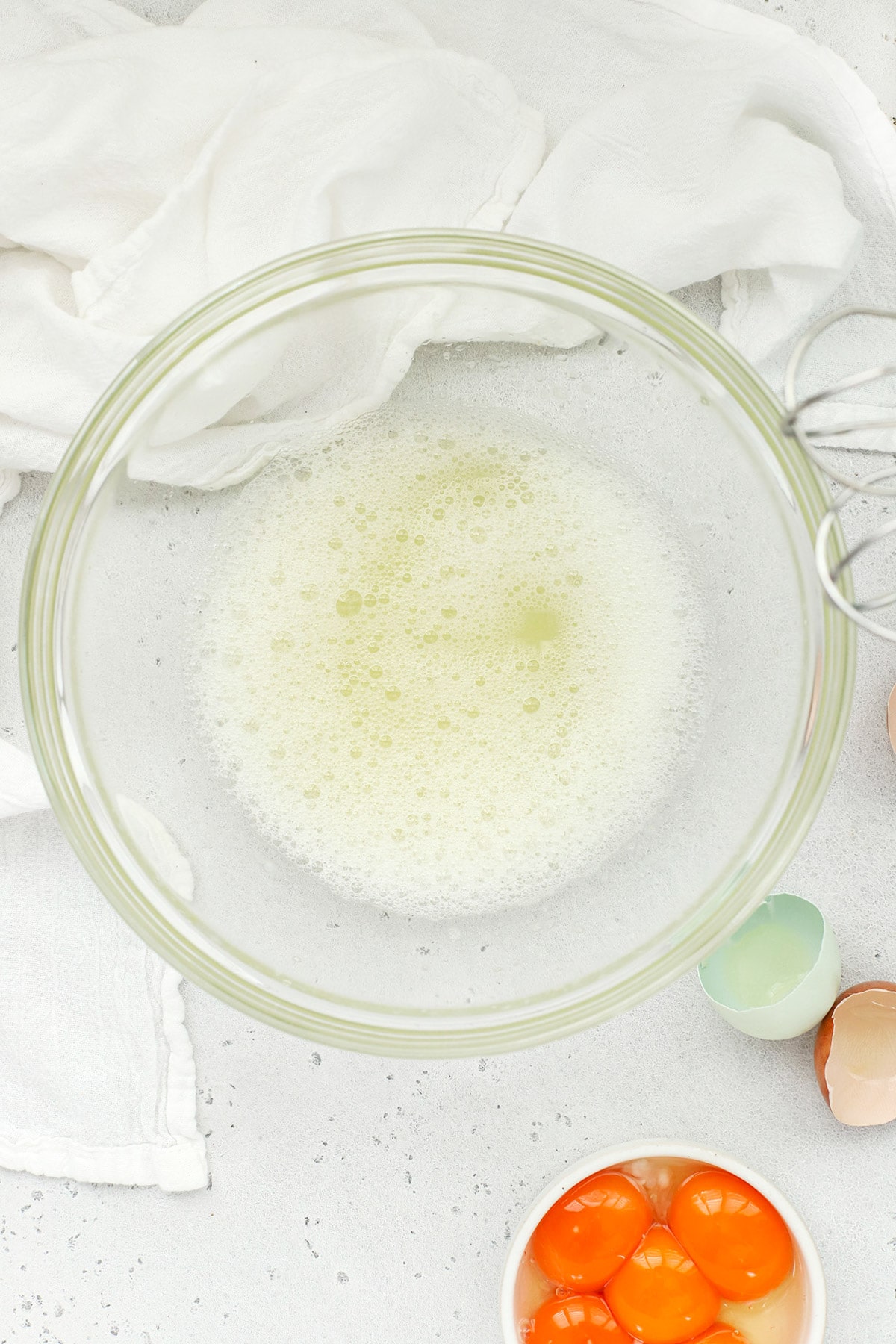 Foamy egg whites in a glass bowl