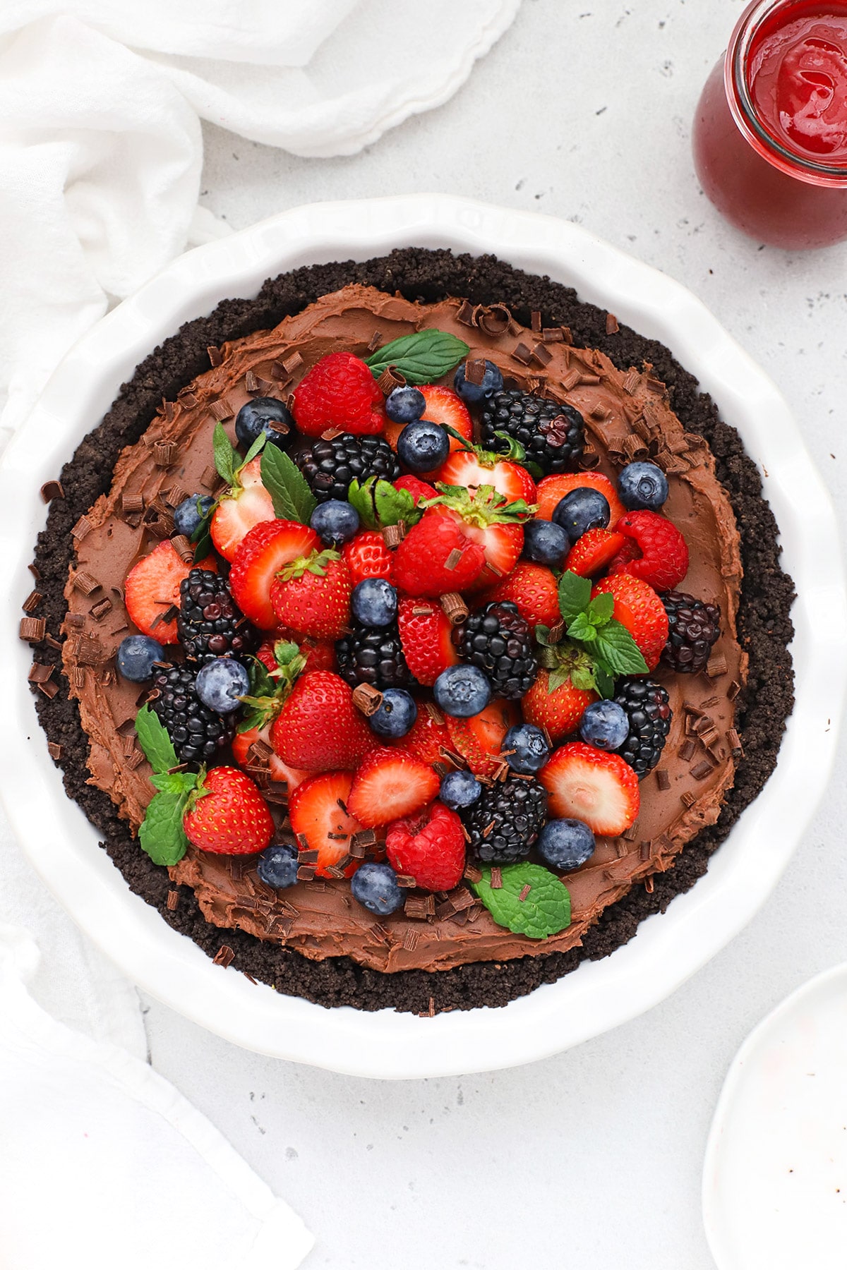 Overhead view of no-bake gluten-free chocolate cheesecake pie topped with fresh berries
