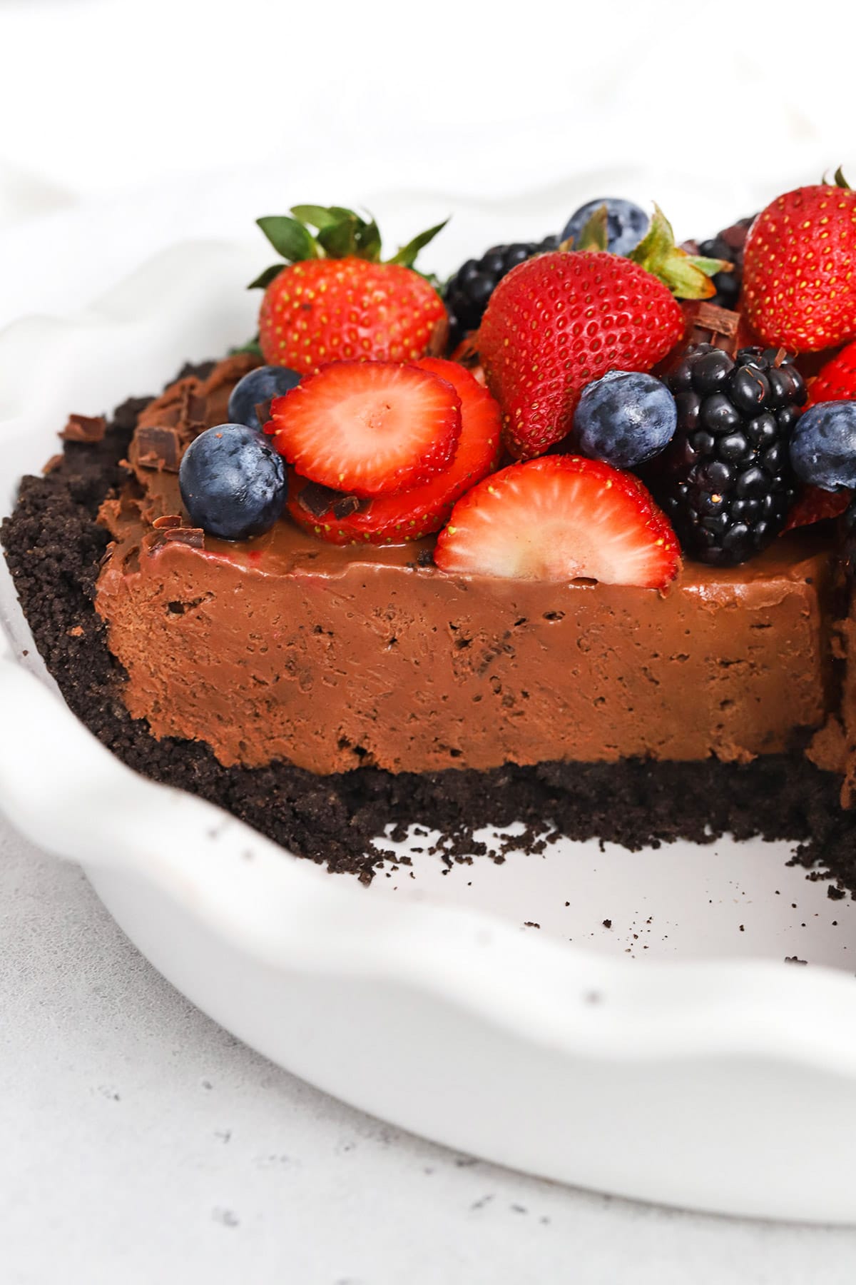 Front view of no-bake gluten-free chocolate cheesecake pie topped with fresh berries