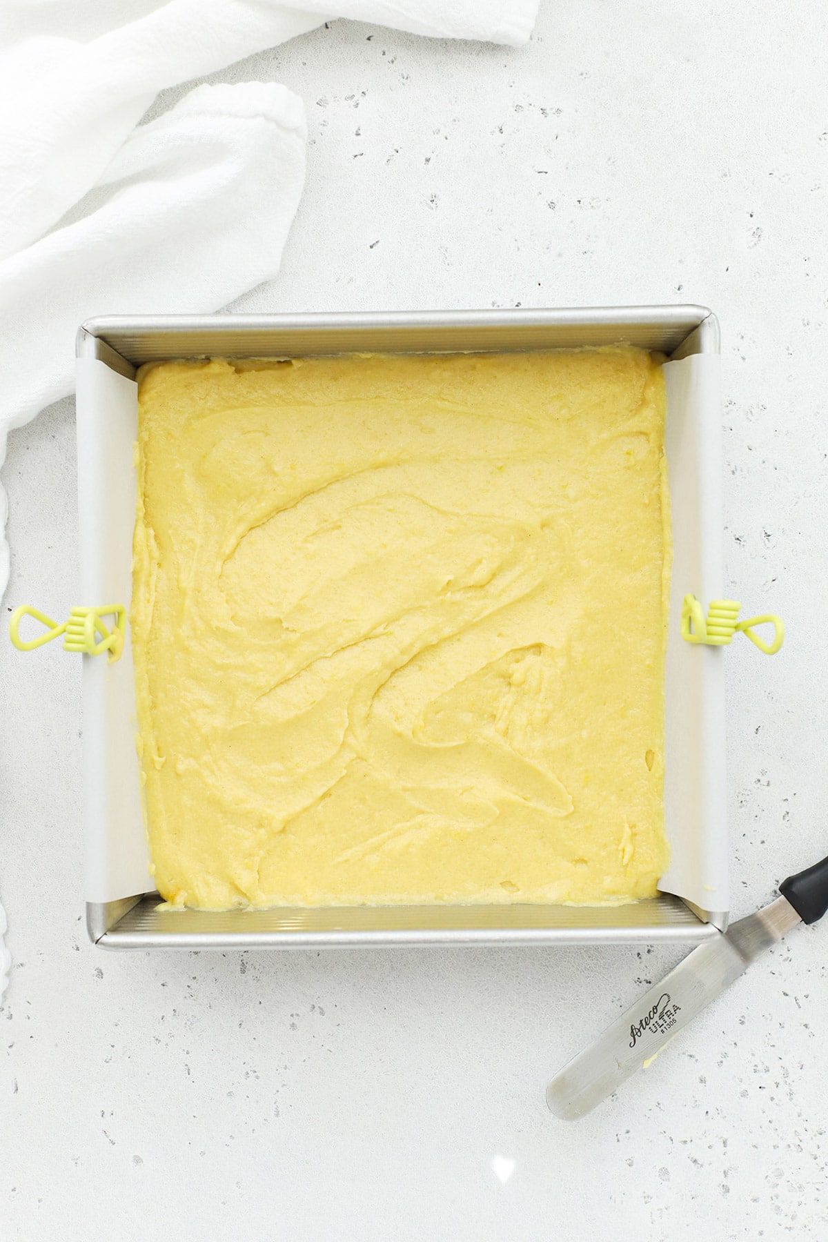 Spreading gluten-free lemon brownie batter into a baking pan
