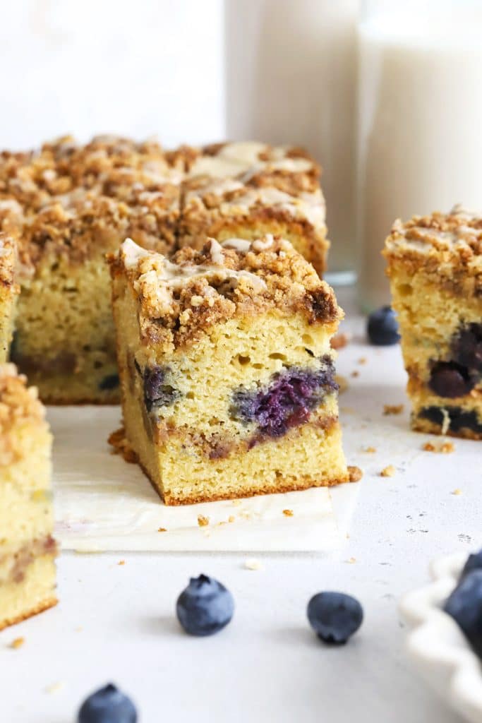 Front view of a slice of gluten-free blueberry coffee cake with cinnamon streusel & glaze