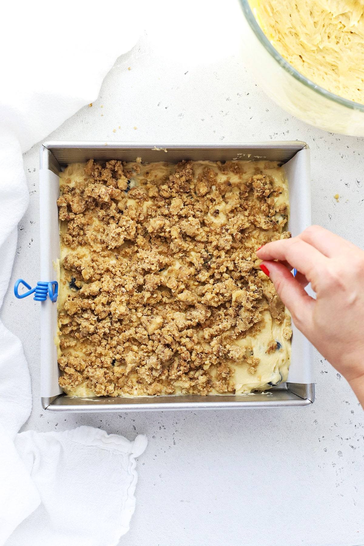 Layering streusel over gluten-free blueberry coffee cake batter