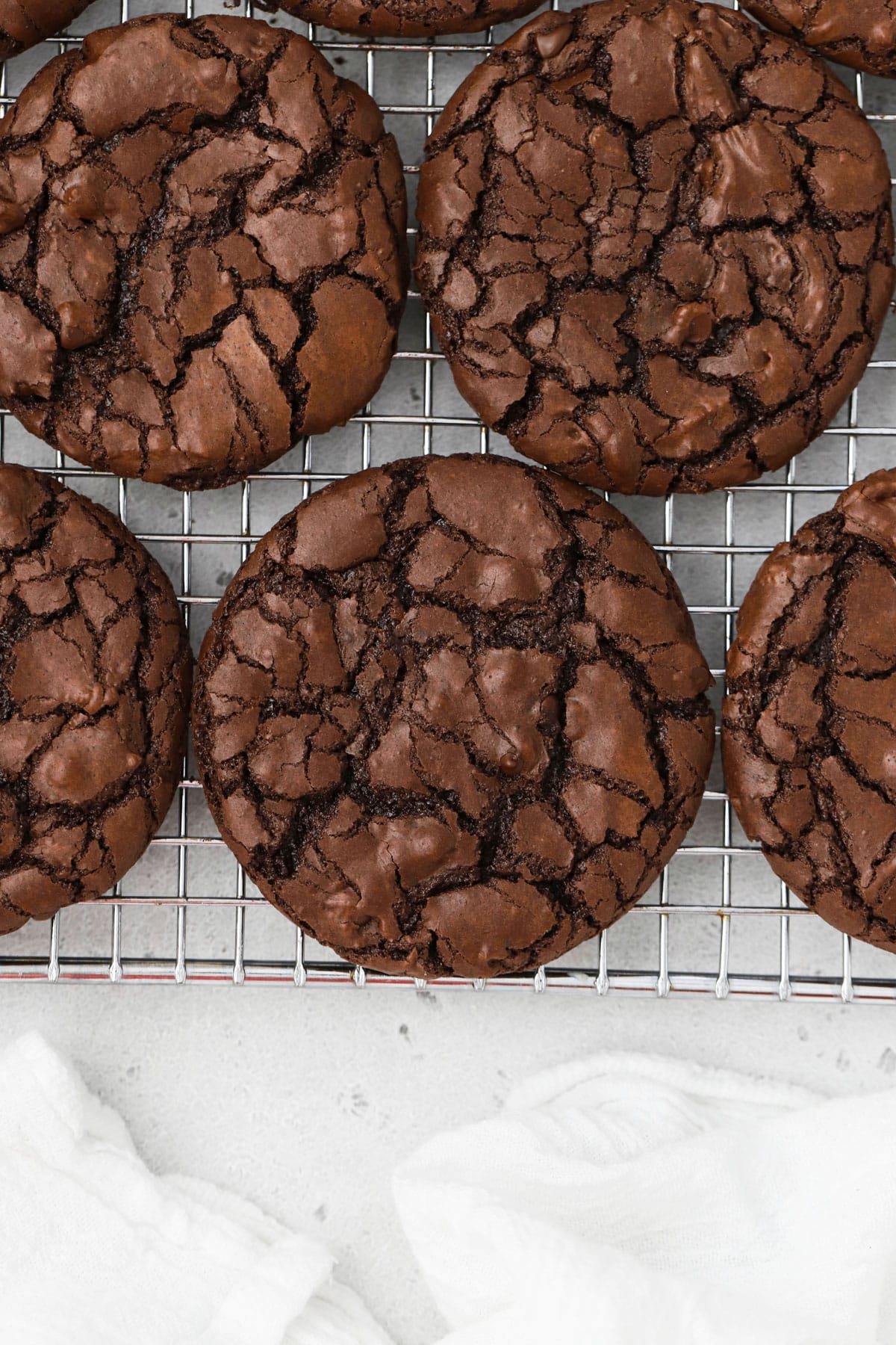 Glossy gluten-free brownie cookies cooling on a wire rack