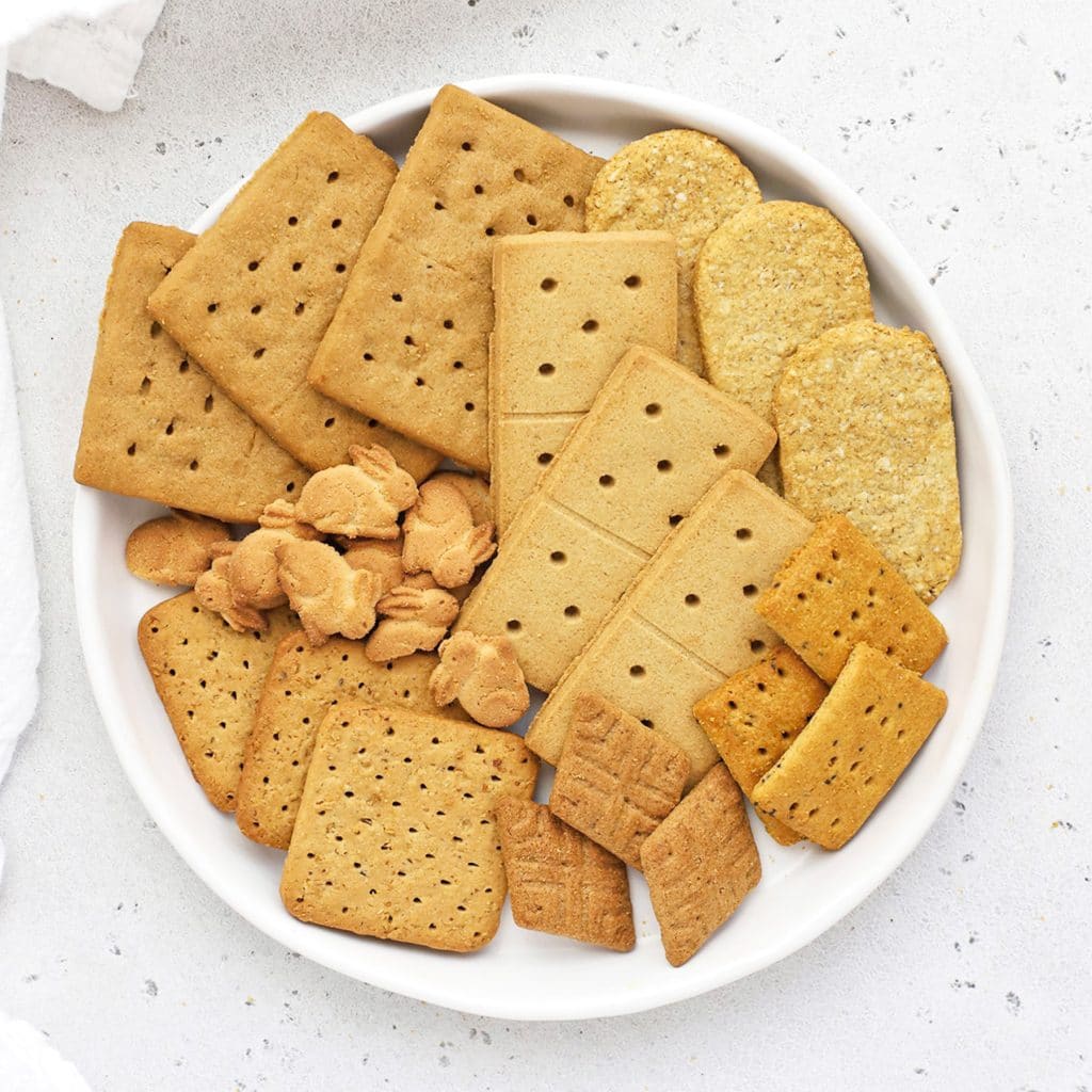 Overhead view of different kinds of gluten-free graham crackers on a white plate