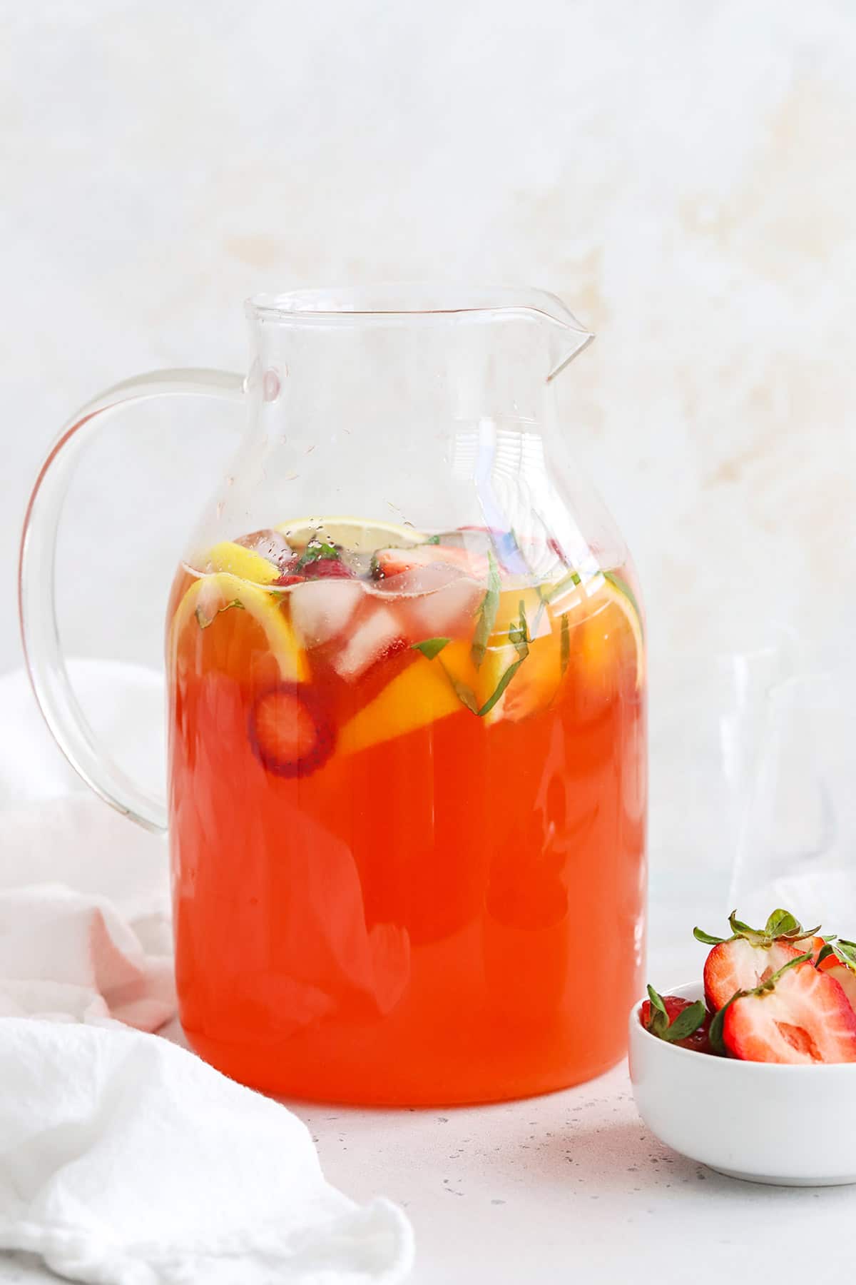 Front view of a pitcher of homemade strawberry basil lemonade