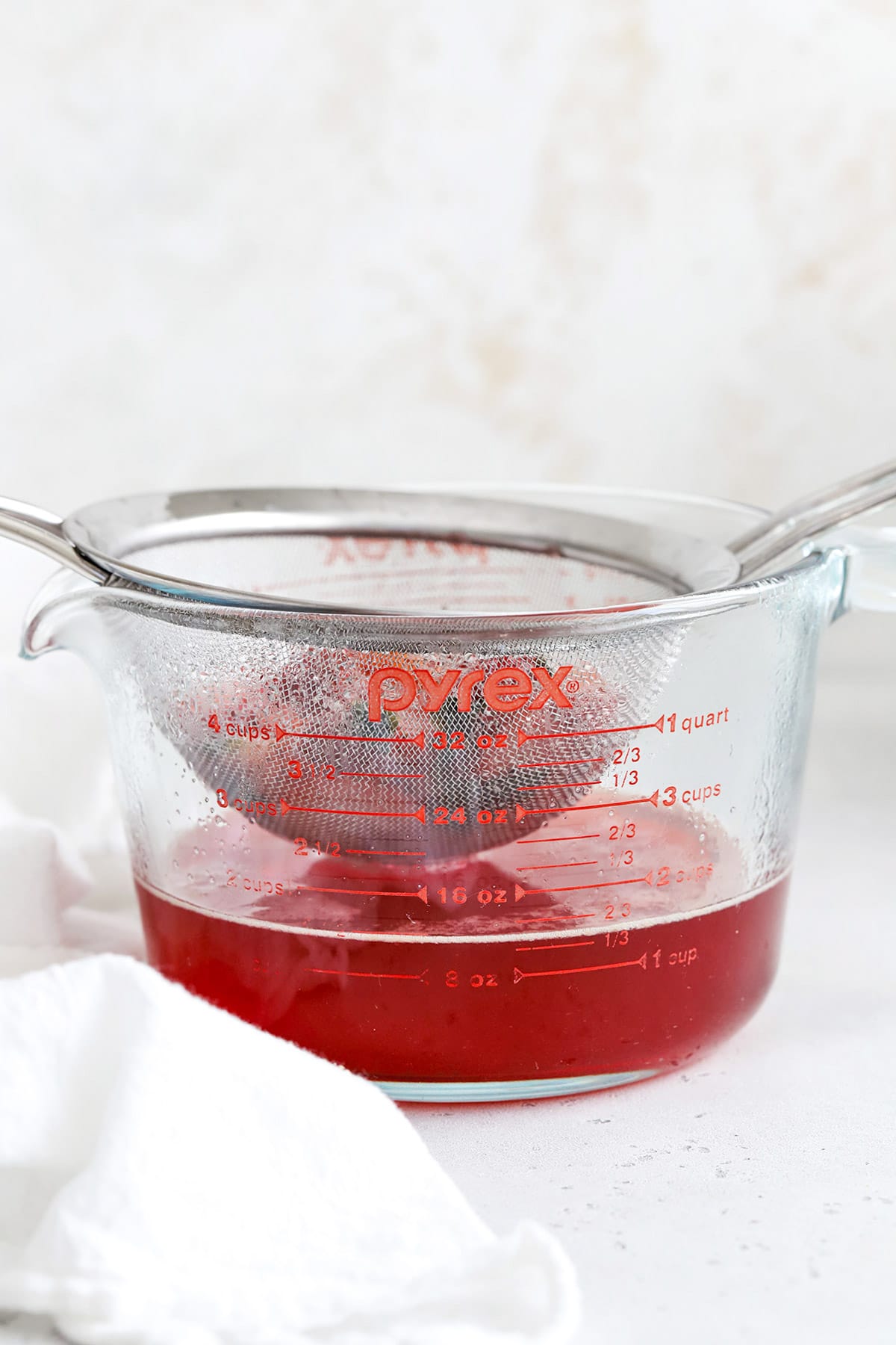 Straining strawberry basil simple syrup