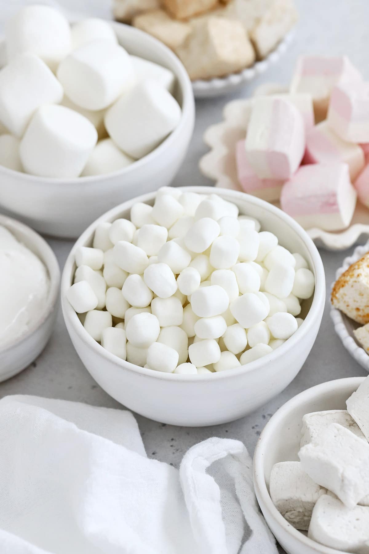Front view of several bowls of gluten-free marshmallows in different sizes, flavors, and shapes