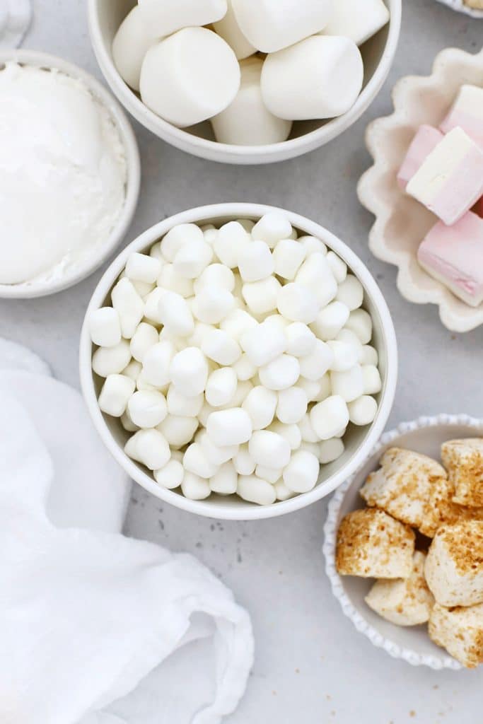 Overhead view of several bowls of marshmallows in different shapes, sizes, and flavors