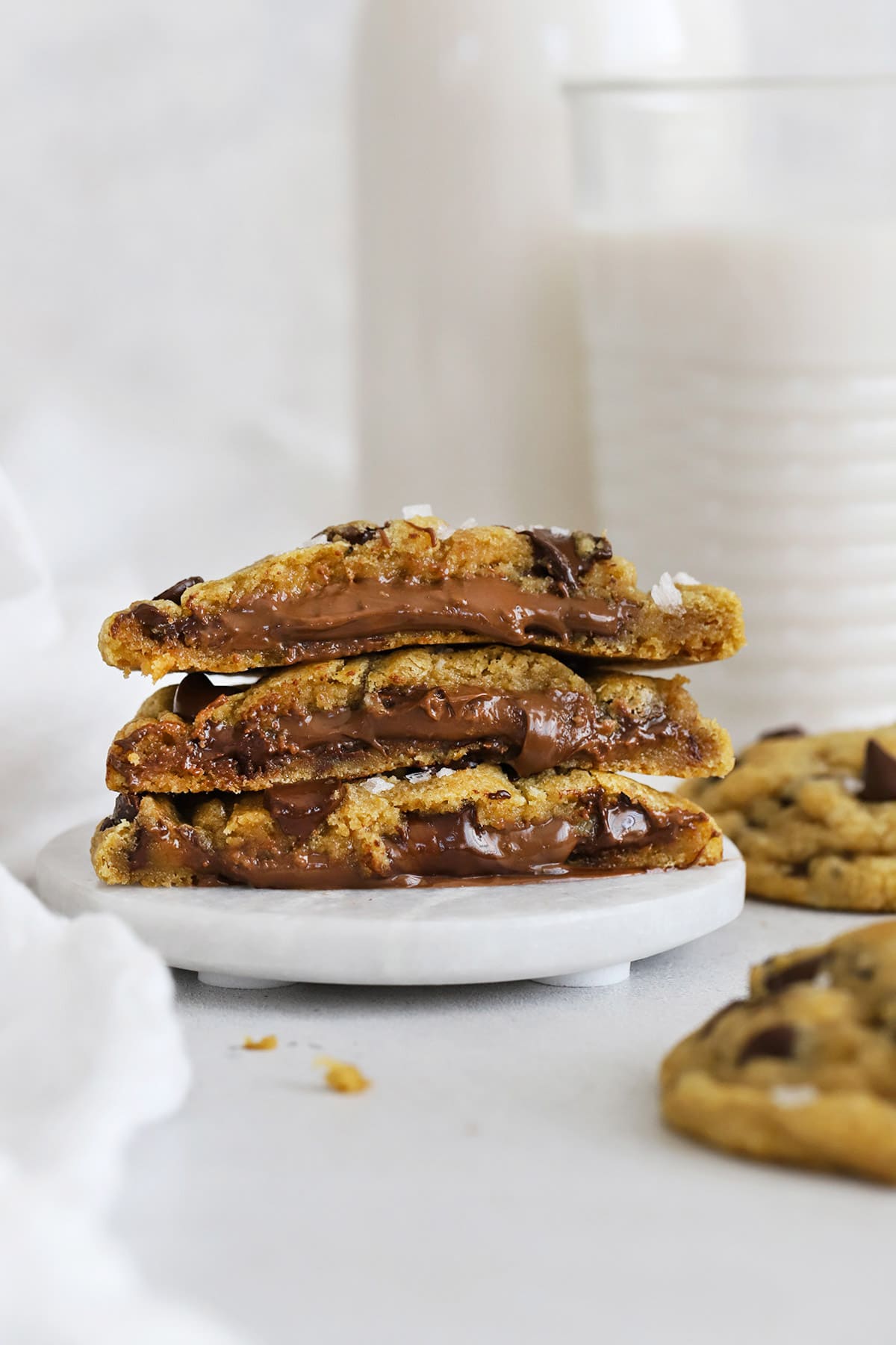 Halved gluten-free Nutella stuffed chocolate chip cookies stacked on top of each other