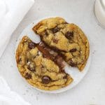 Gluten-free Nutella stuffed chocolate chip cookie being pulled apart to reveal the gooey nutella center
