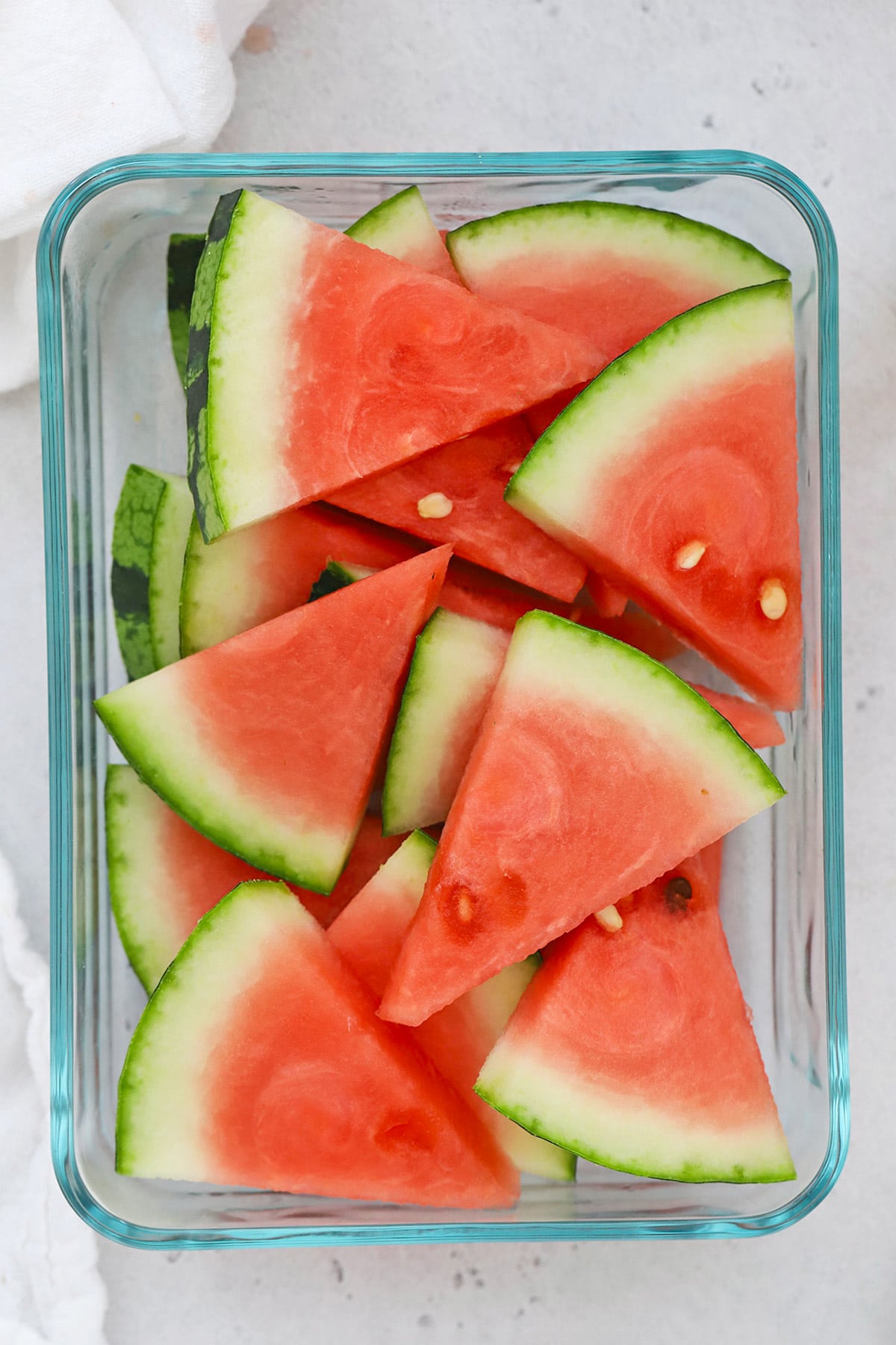Overhead view of sliced watermelon wedges in a glass container