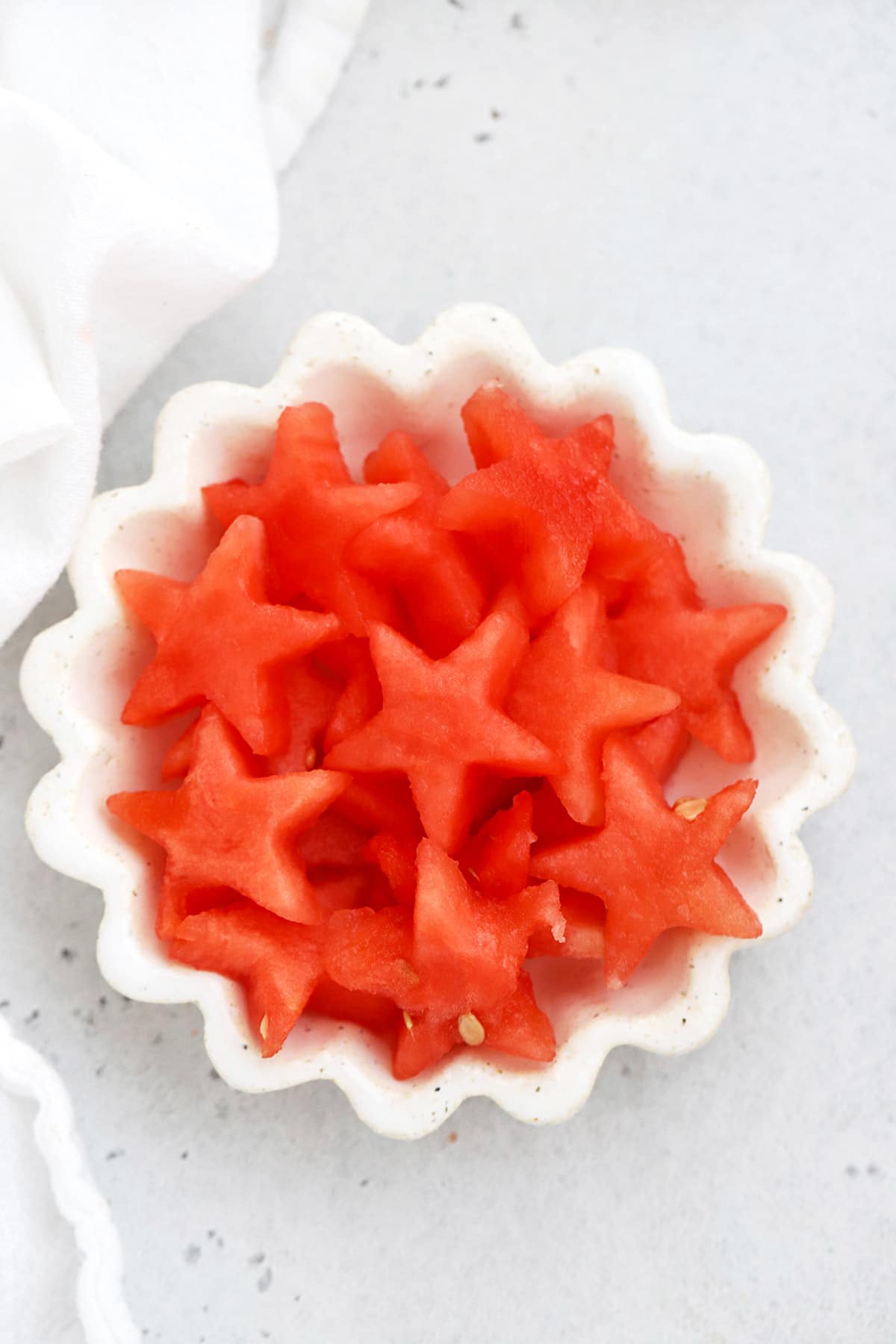 Overhead view of watermelon star cutouts in a white ruffled dish